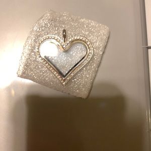 Heart shape locket with diamonds around it